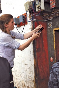 Meg installs a GridShare device in Rukubji. (Photo credit Arne Jacobson.)