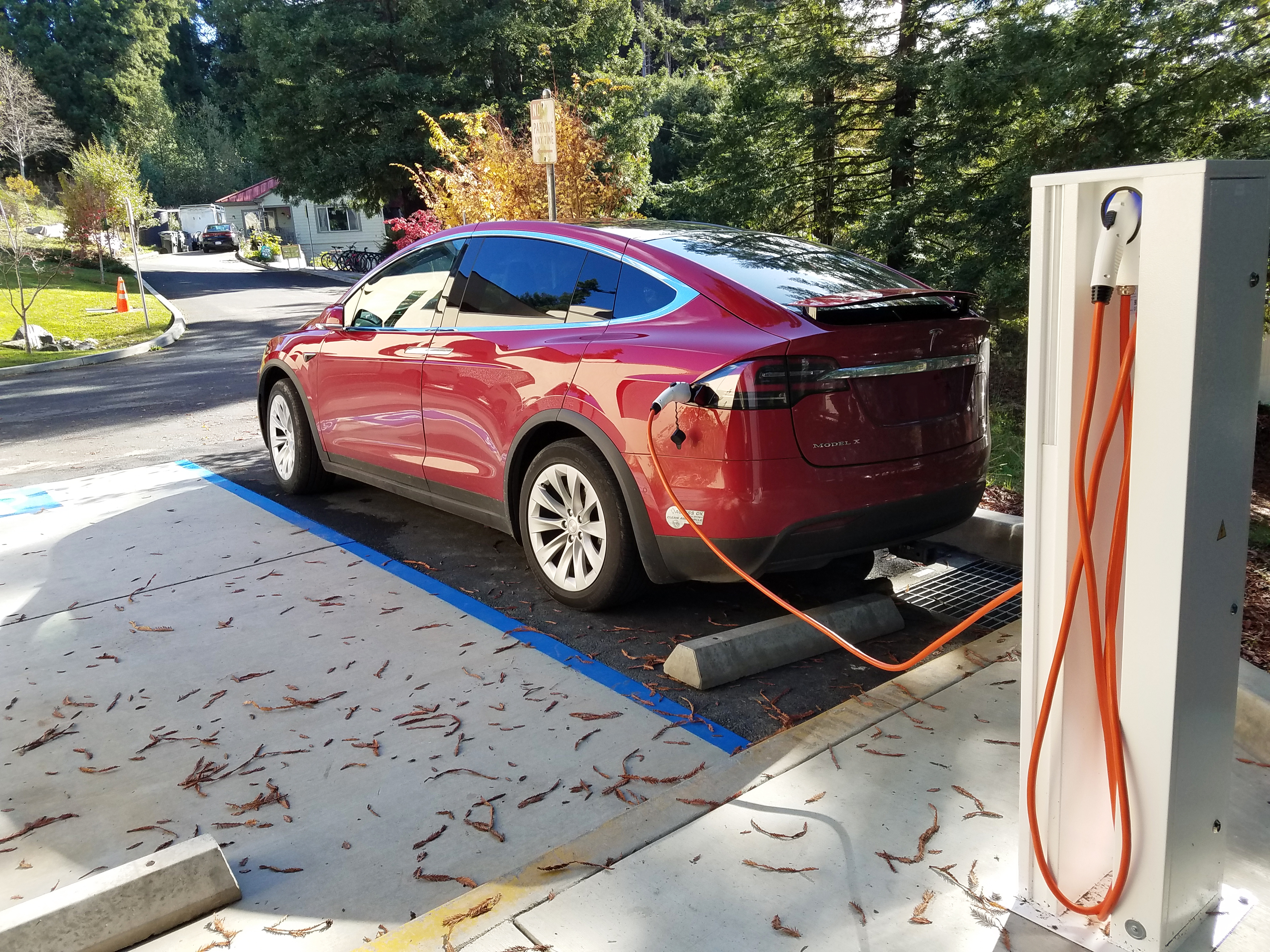 A red Tesla is charging at the Schatz EV station.