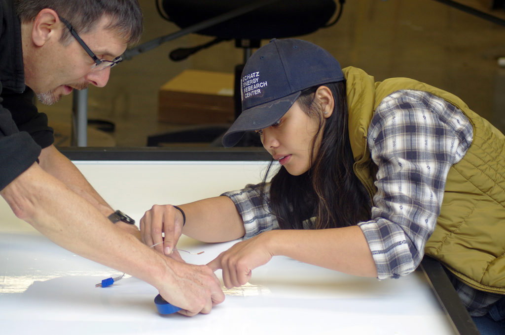 Jim and Carisse set a thermocouple on the white backside of a module