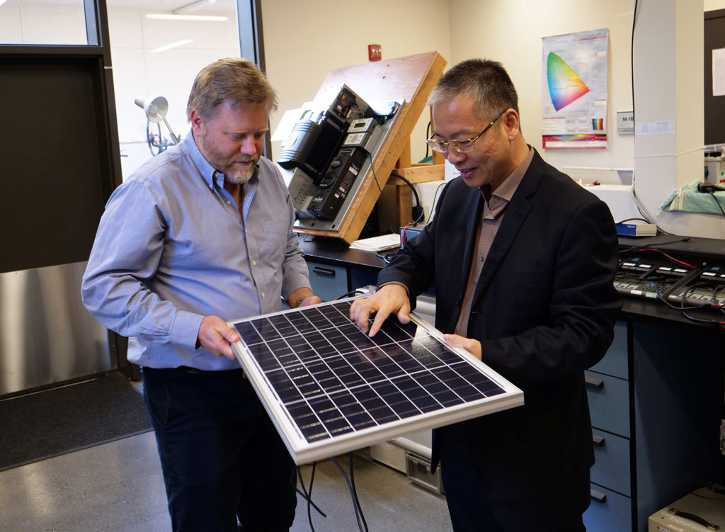 Arne Jacobson and Honglin Hui inspect a solar module in the Center's test lab