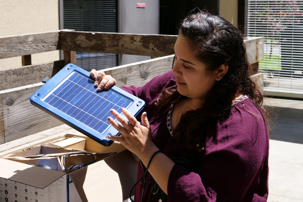 A student research assistant unpacks solar products.