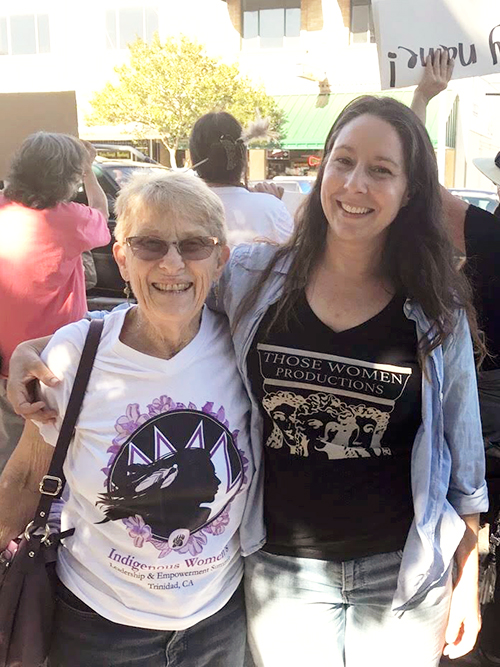 Alicia Littletree-Bales and Naomi Wagner stand beside eachother, hugging, at a march