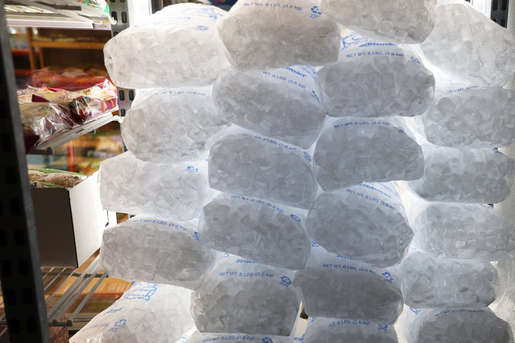 A stack of ice bags, seen from the inside of a refrigerator