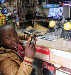 A child holds a solar product while standing at a store counter