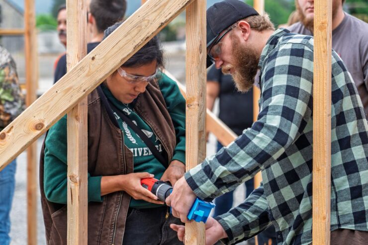 Two people work together to build a structure