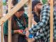 Two people work together to build a structure