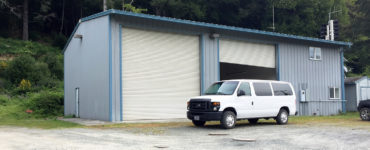 A white van is parked in front of the fire station