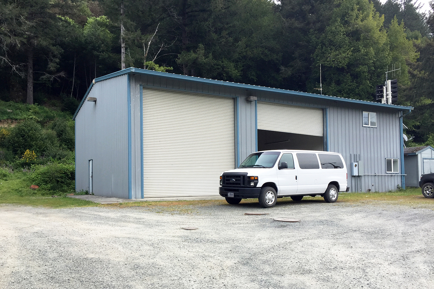 A white van is parked in front of the fire station