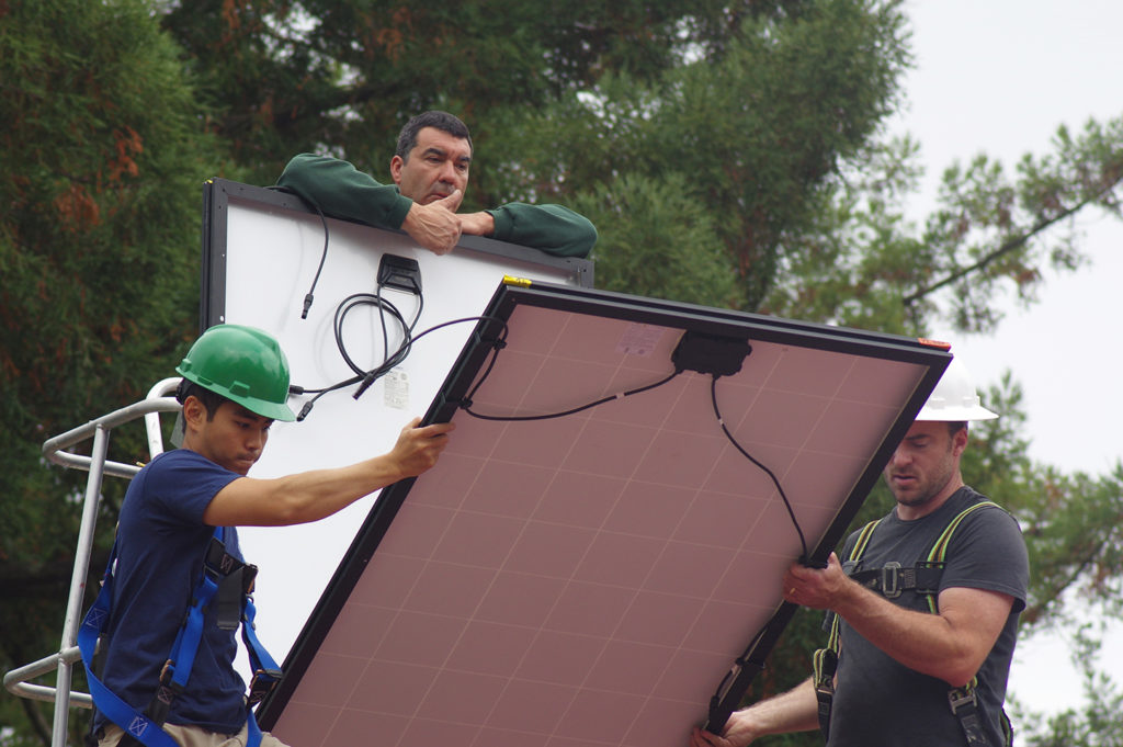 Chih-Wei and Ray remove a panel from the stack on the lift, while Charles holds the remainder