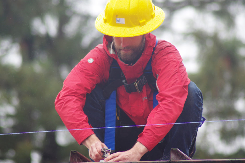 Craig twists a module mount near the edge of the roof