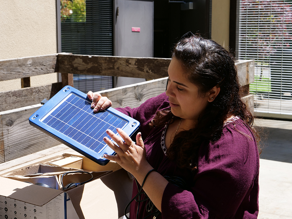 Tanya Garcia unpacks a solar module in the Schatz courtyard.