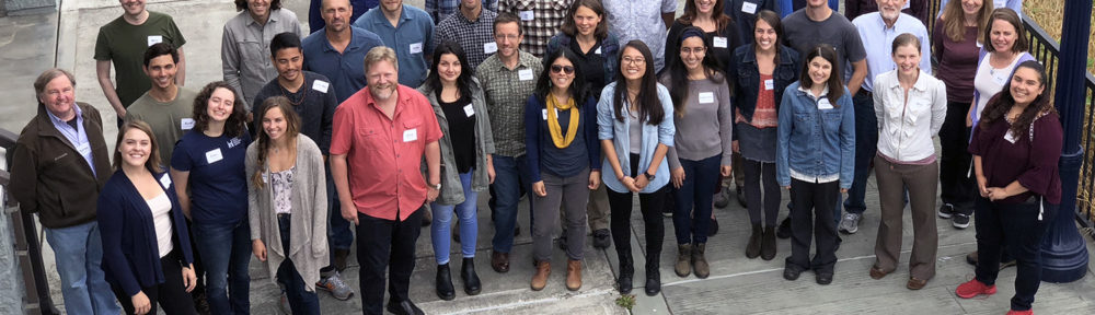 A group photo of 35 staff standing outside the Wharfinger Building in Eureka