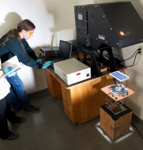 Two engineers use a solar simulator to test a solar module
