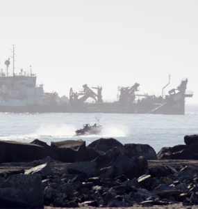 A dredge ship and small fishing boat in the mouth of Humboldt Bay)
