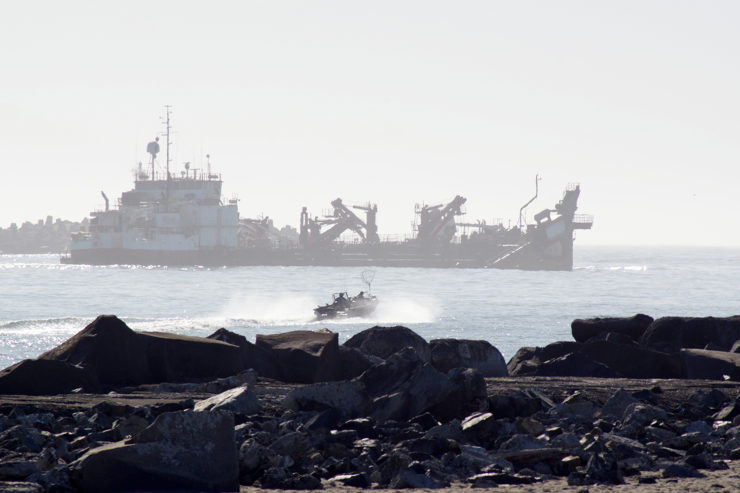 A dredge ship and small fishing boat in the mouth of Humboldt Bay)