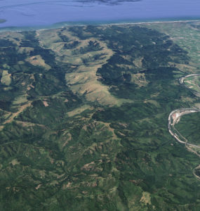 Aerial shot of mountains, with Highway 101 and the town of Scotia to the left, and the Pacific Ocean to the north