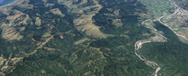 Aerial shot of mountains, with Highway 101 and the town of Scotia to the left, and the Pacific Ocean to the north