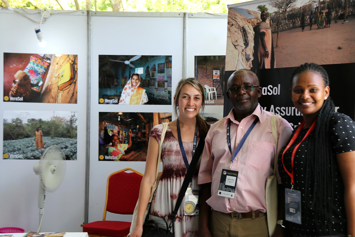 3 people stand together in a booth with VeraSol posters behind them