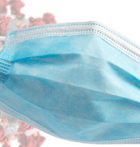 A blue surgical mask is superimposed over a graphic of a coronavirus