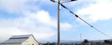 A utility pole in the foreground, with a barn in the background