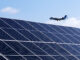 An airplane flies above the microgrid's solar array